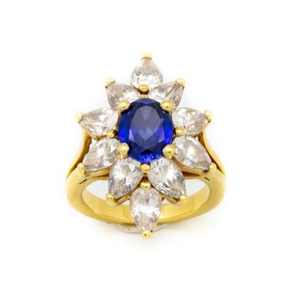 null Important yellow gold ring forming a flower, the center adorned with a blue...