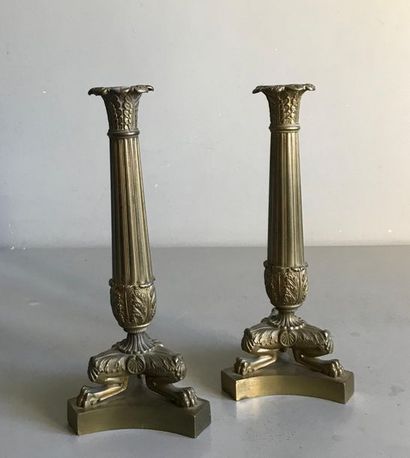 null Pair of candlesticks in patinated bronze. The fluted shaft is surmounted by...