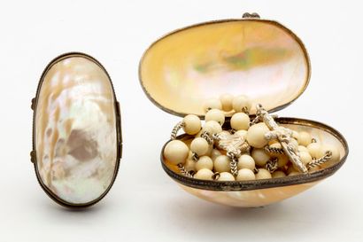 null Two mother-of-pearl eggs with metal rings, inside a rosary.