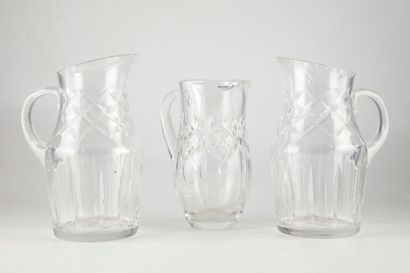 null Pair of cut crystal jugs. One pitcher is attached to the different model in...