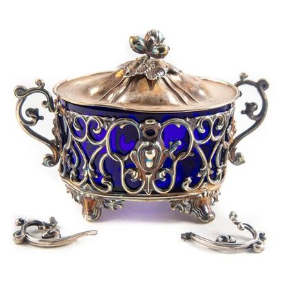 null Oval shaped sugar bowl with silver frame with arabesque motifs showing a blue...