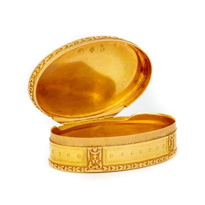 null Oval-shaped box in two-tone gold. The hinged lid is decorated on a guilloche...