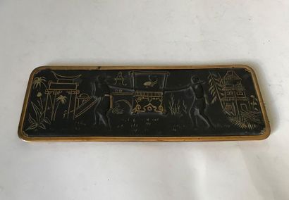 null Metal pen tray with gold decoration on a black background of a scene in the...