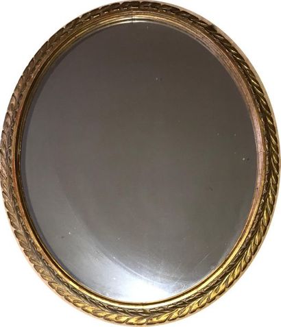 null Oval shaped mirror with gilded wood frame chiselled with a frieze of leaves....