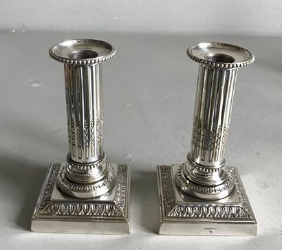 null Pair of small silver bronze candleholders in the shape of a fluted column resting...