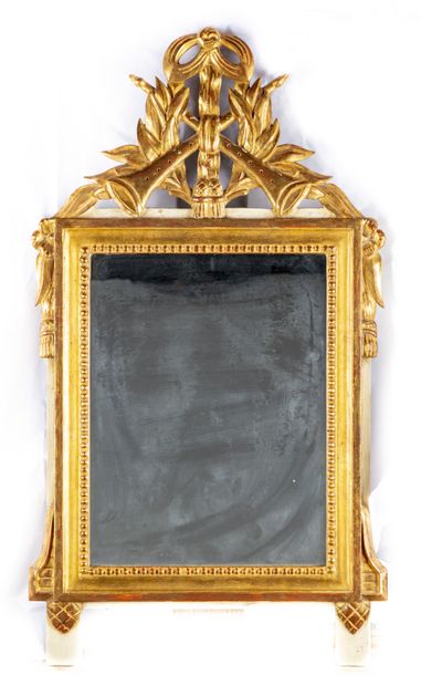 null Miroir en bois doré et sculpté, le fronton à décor de trompettes, miroir encadré...