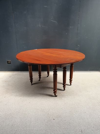 null Mahogany and mahogany veneer dining table. Round top with flaps resting on six...