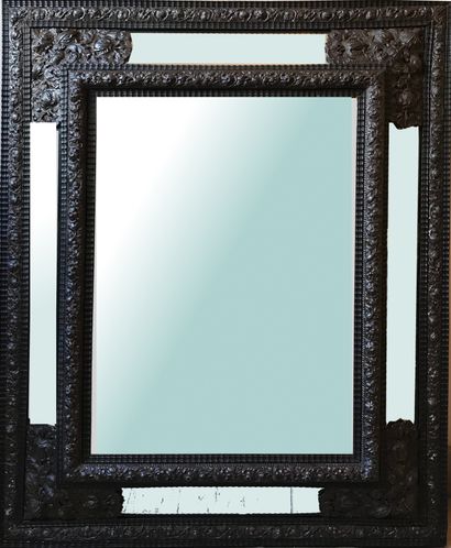 null A large mirror with a frame of blackened wood and patinated brass, openwork...