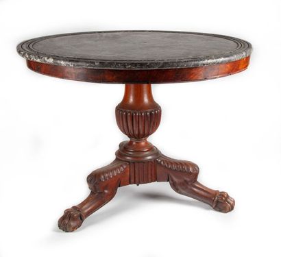 null A round pedestal table resting on a mahogany veneered baluster shaft with three...