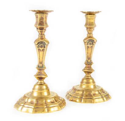 A pair of ormolu candlesticks, the three-sided...