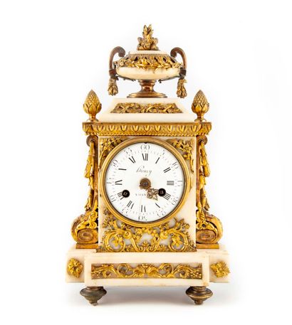 A white marble clock richly decorated with...