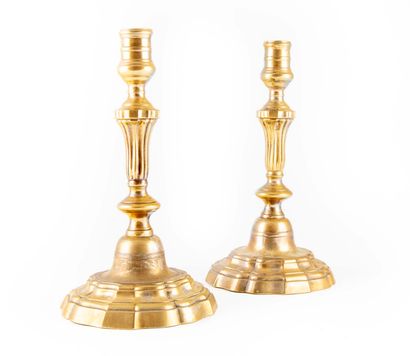 A pair of bronze candlesticks with fluted...