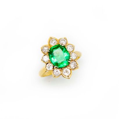 Yellow gold daisy ring set with an emerald...