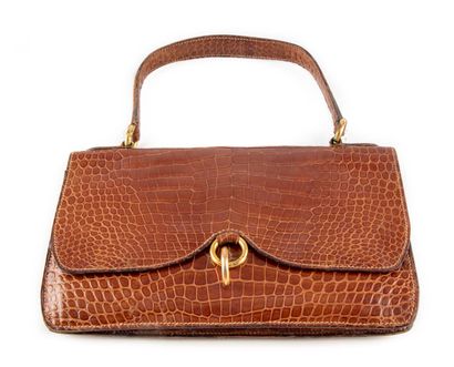null Small brown crocodile bag with leather lining. Handle with golden rings.

Circa...
