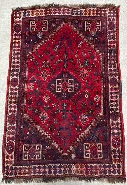 null Woolen carpet with geometrical patterns on a red background, the border with...