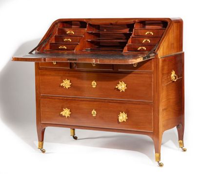 null A mahogany chest of drawers opening to four drawers and a flap revealing six...