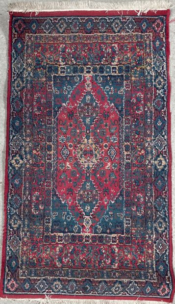 null Woolen carpet with motifs on a red background of a central medallion of rectangular...