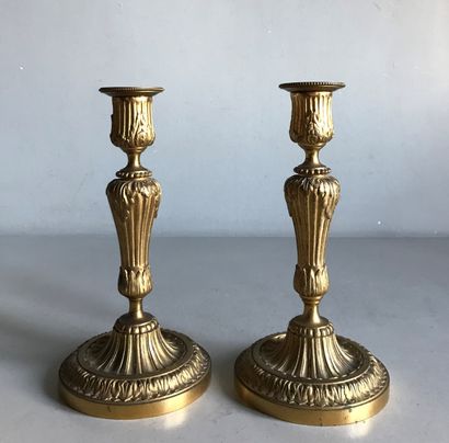 null A pair of ormolu candlesticks molded and chased with flutes, acanthus leaves,...