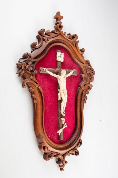 null Christ in ivory carved on a wooden cross

Framed in carved wood with leaves

Late...