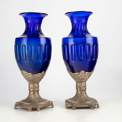 null A pair of blue tinted glass vases on a regula base decorated with flowers and...