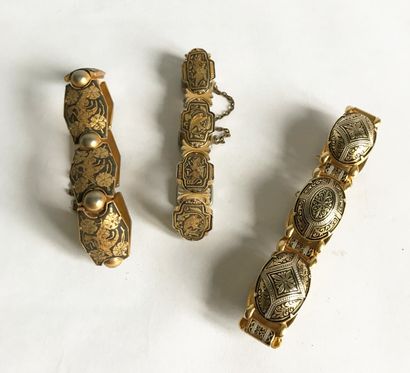 null Three gilt metal bracelets decorated in the Toledo damascene style.