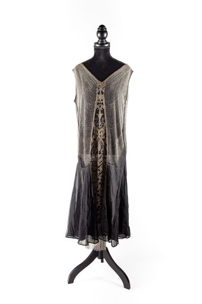  Vers 1920 
Robe en gaze de soie noire ornée d'une broderie en perles de verre 
Petits...
