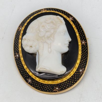  Vers 1880 
Broche camée ovale sur onyx gravé d'un profil de femme, entourage d'émail...