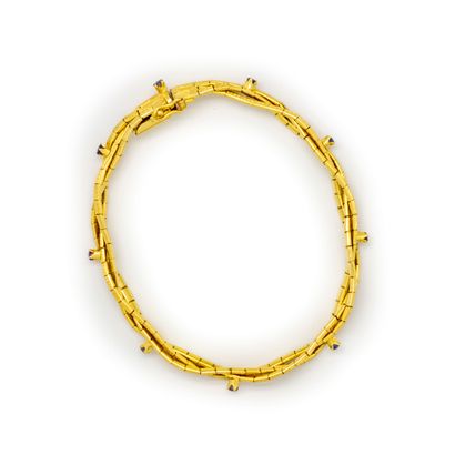  Bracelet en or jaune (750e) constitué d'une tresse de trois lignes de maillons souples...
