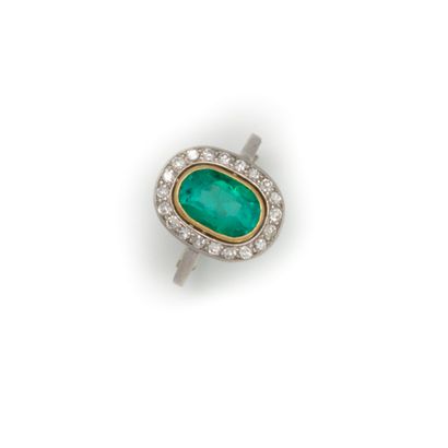  White gold ring set with an oval emerald, surrounded by diamonds 
TDD : 54 
Gross...