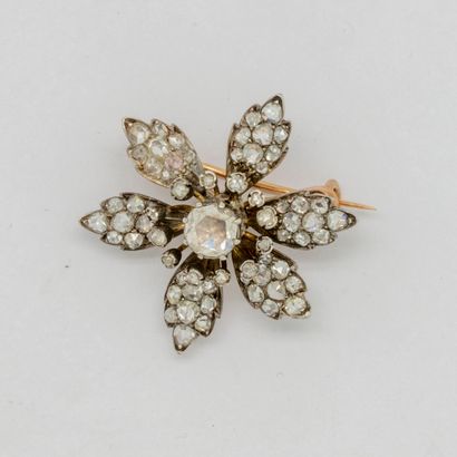  Yellow gold brooch forming a flower with a central old-cut diamond, the petals adorned...