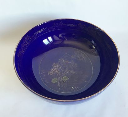 null Large round porcelain salad bowl with gilded decoration on a blue background...