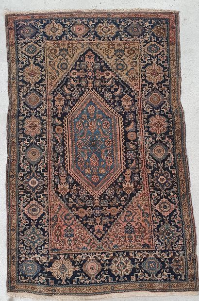 Persian wool carpet decorated with a central...