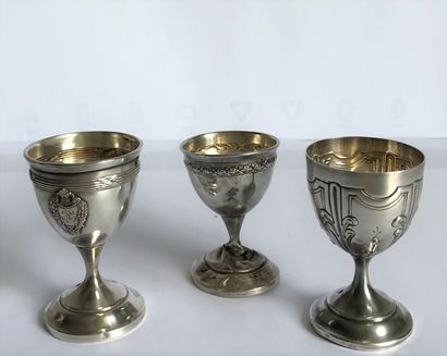 Three egg cups on foot in silver molded and...