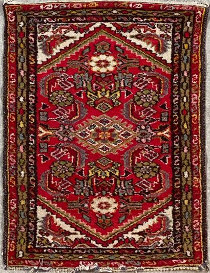  Petit tapis en laine à décor géométrique sur fond rouge, et triple bordure 
86 cm...
