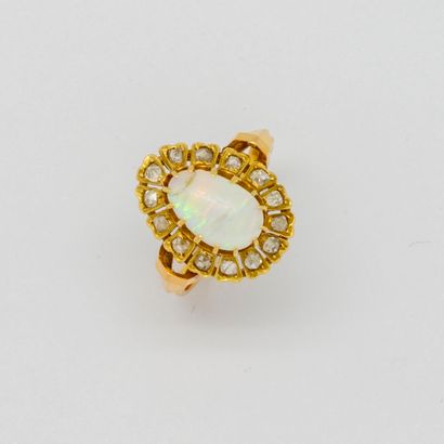  Bague en or jaune de forme ovale ornée en son centre d'une opale entourée de petits...