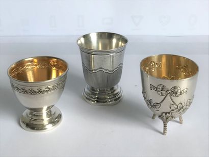 Three egg cups on heel or tripod in silver...