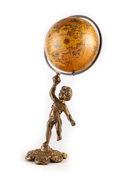 Small brass putto supporting a globe 
H....