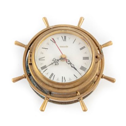  Clock in the shape of a ship's rail in brass, the dial with Roman numerals signed...
