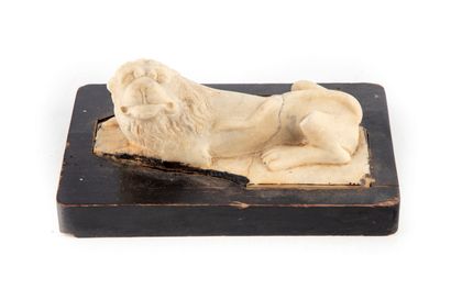 Reclining lion, sculpted in stone on a wooden...