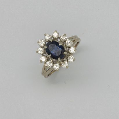  White gold ring set with a sapphire surrounded by small diamonds 
Weight : 3,82...