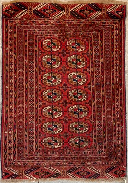 null Bukhara type wool carpet with geometrical patterns on a red field, with 7 b...