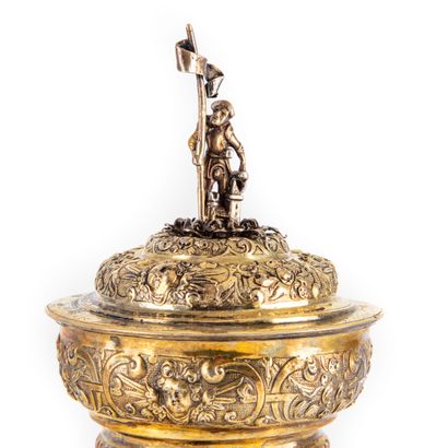 null A silver and vermeil covered cup of a moving form richly chased with foliage...