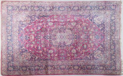 null Important tapis persan à motifs de rinceaux et fleurs sur champ rouge et bleu

440...