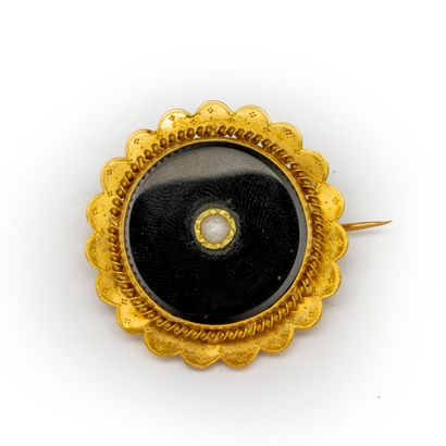  Broche en or jaune ornée d'une onyx et d'une perle 
Poids brut : 5,2 g. 
A VERI...