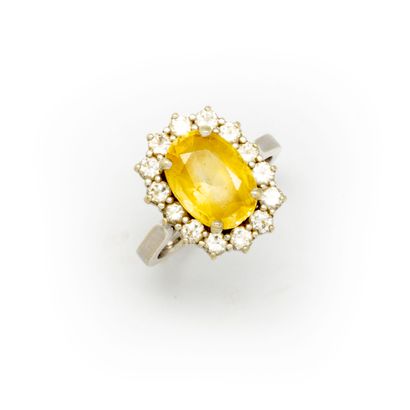 White gold ring with a topaz surrounded by...
