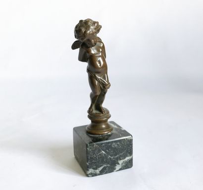 null Presse-papier en bronze patiné représentant un angelot sur un socle en marbre....