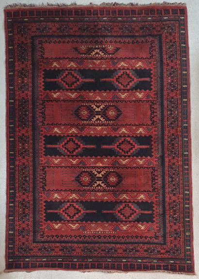 null Turkish wool carpet decorated on a red and dark blue background with horizontal...