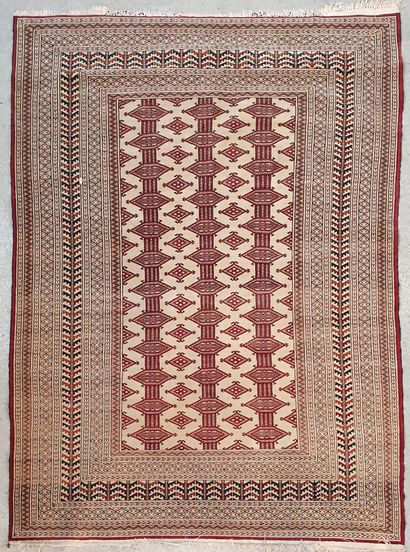 null Persian carpet decorated on beige field of three lines of stylized motifs of...