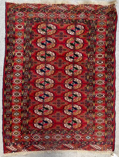 null Wool carpet decorated with small medallions on a red field and a central medallion,...