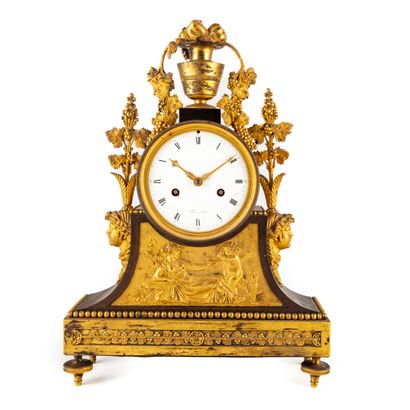 null Clock in gilded and patinated bronze. The dial rests on a triangular base decorated...